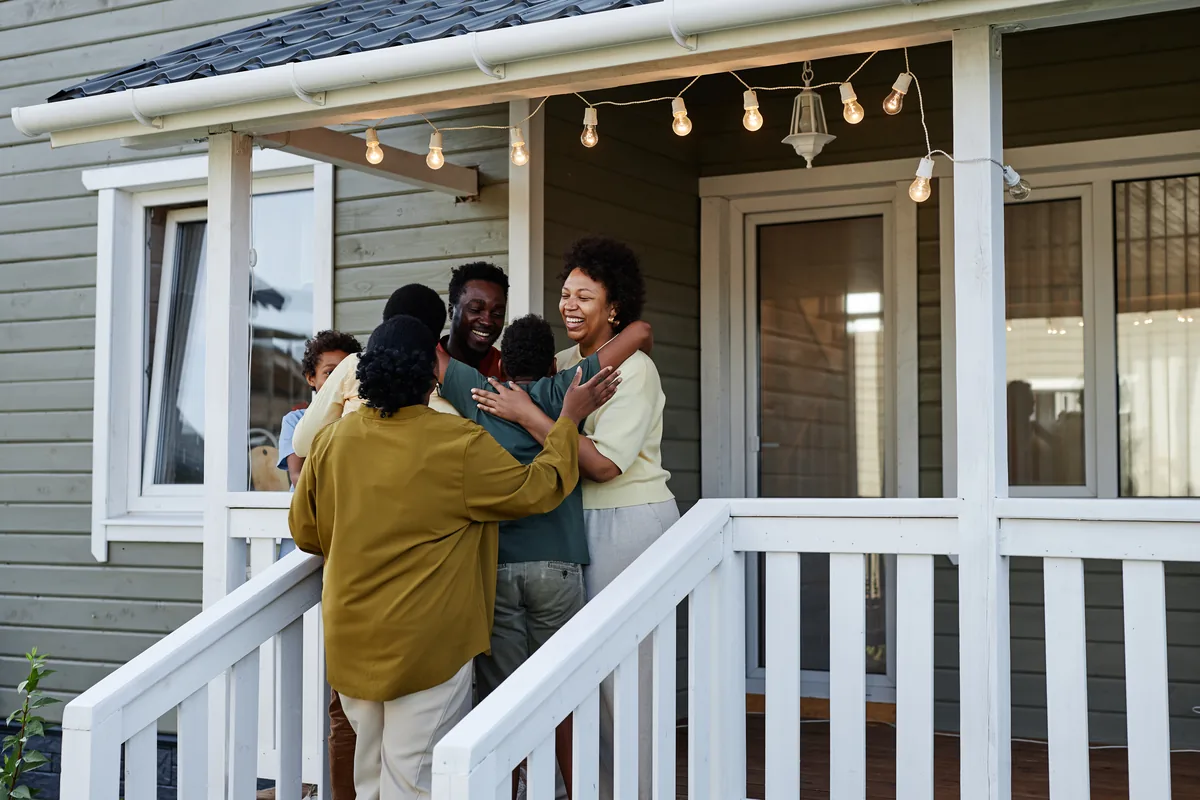 Family gathered for hugs on the front porch of a home